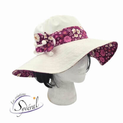 capeline d'été en coton blanc avec bande de tour de tête et dessous du bord en coton rose fleuri vu de côté avec fleur