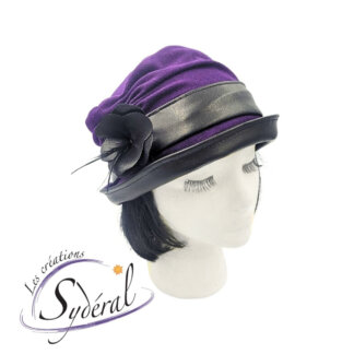 chapeau style cloche en lainage mauve et cuir synthétique noir vu de côté avec le bord relevé avec fleur décorative